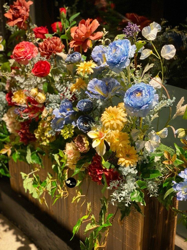 夜間近拍木製花箱的花材配色、葉材與垂墜長春藤。