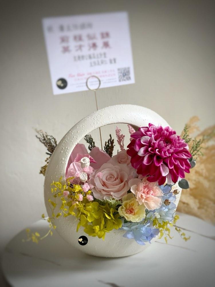 桃紅與粉色花材搭配藍色繡球花及白色花器的祝賀花禮